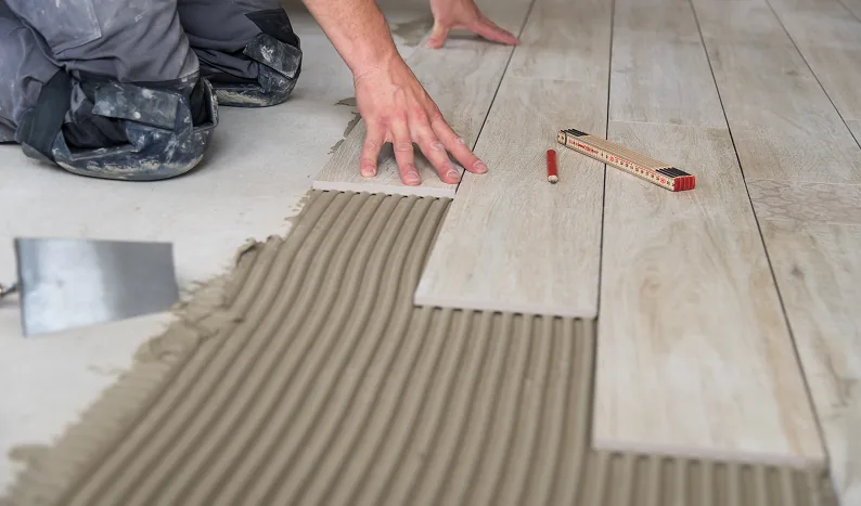 Fliesenleger verlegt Bodenfliesen in Holzoptik