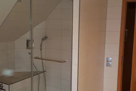 Dusche mit Glasabtrennung unter der Dachschräge