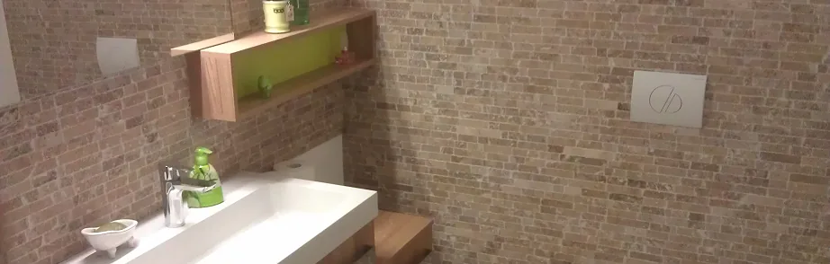 Waschtisch vor einer Wand mit Naturstein-Riemchen
